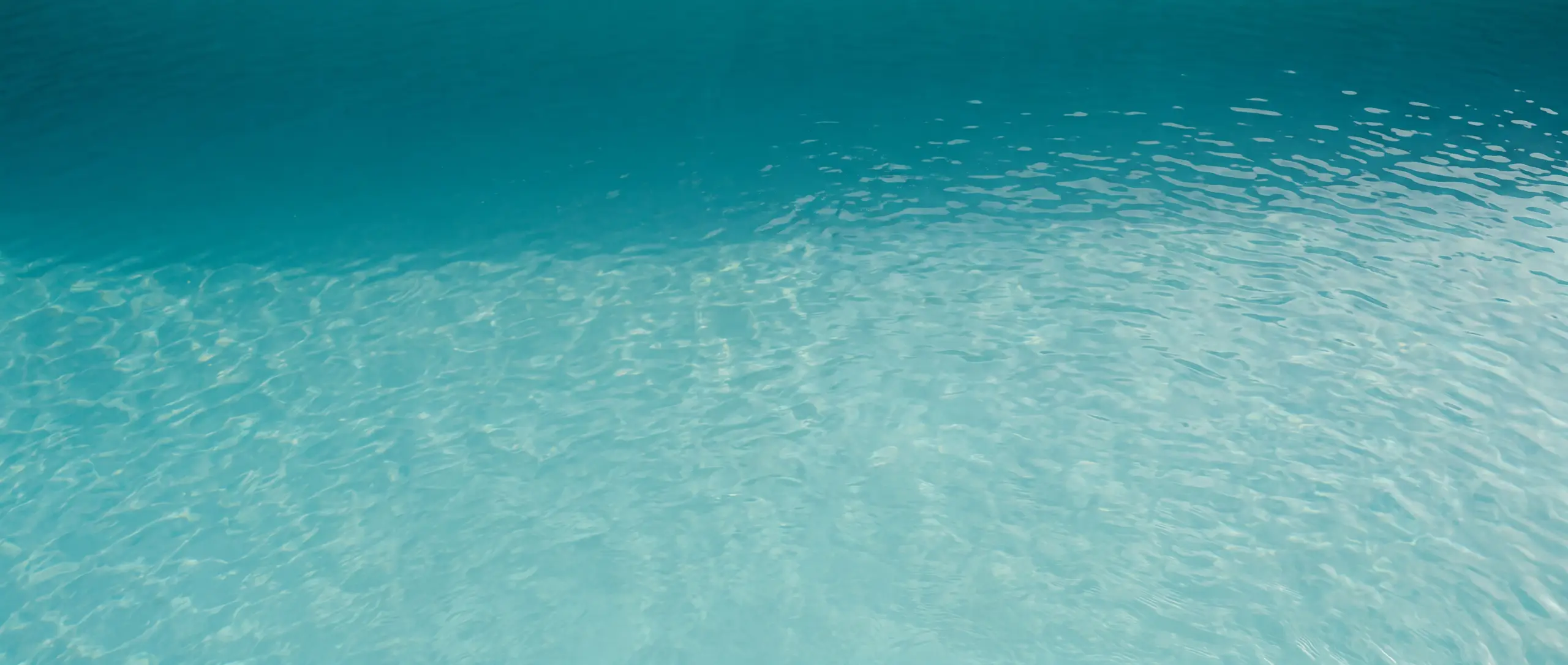 Pool water seen from above, deep teal grading to lighter aqua.
